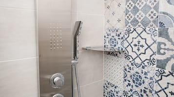 A shower with a handheld showerhead and a wall-mounted control valve.