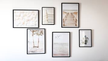 Una pared con seis cuadros enmarcados, cada uno mostrando diferentes escenas de playa.