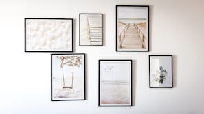 Una pared con seis cuadros enmarcados, cada uno mostrando diferentes escenas de playa.