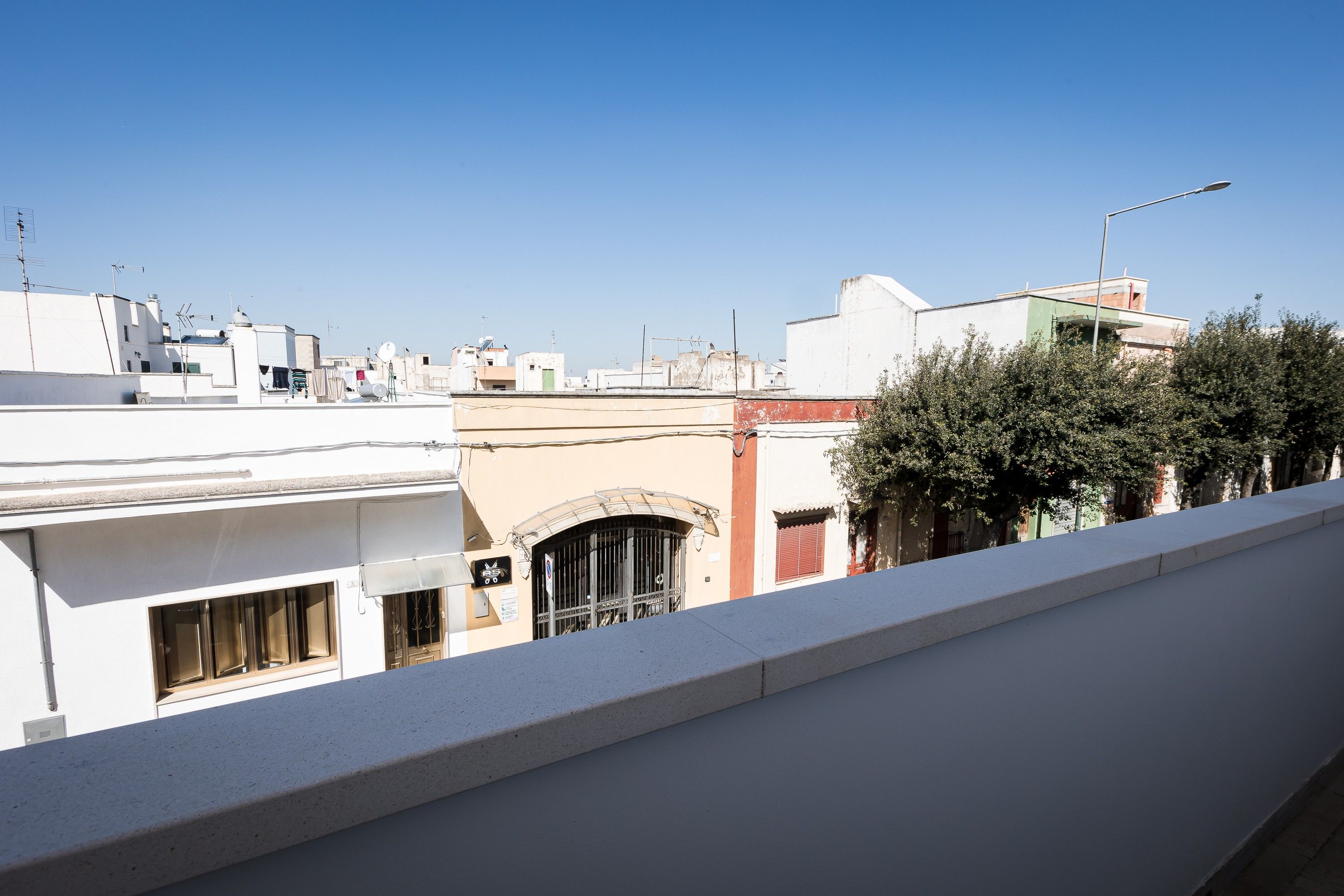 A residential area with buildings, a clear sky, and a streetlight.