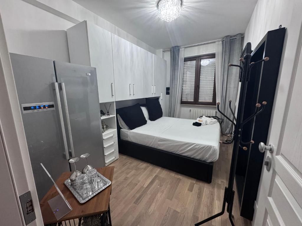 Ein gemütliches Schlafzimmer mit Bett, integriertem Kleiderschrank, Kühlschrank und Nachttisch mit Ablagefläche.