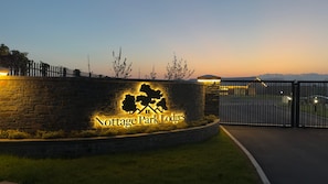 A stone wall with a lit-up sign for Nottage Park Lodges. - Nottage Park Lodges (Nottage)