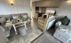 Cozinha compacta com área de refeições, sofá e radiador.