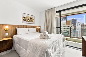 A hotel room with a large bed, a city view, and a wooden headboard. - ZN Barra 600m From Farol da Barra Beach by Carpediem (Salvador)