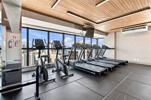 A gym with treadmills, elliptical machines, and a weight bench. - ZN Barra 600m From Farol da Barra Beach by Carpediem (Salvador)