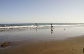 Uma praia com areal e ondas calmas.