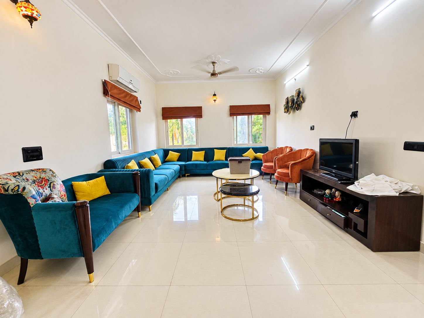 A living room with a sectional sofa, a coffee table, a TV stand, and a ceiling fan.