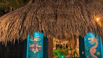 Una estructura de techo de paja con un letrero que dice 'BUENAVISTA, BACALAR QROO. Reset Retreats'.
