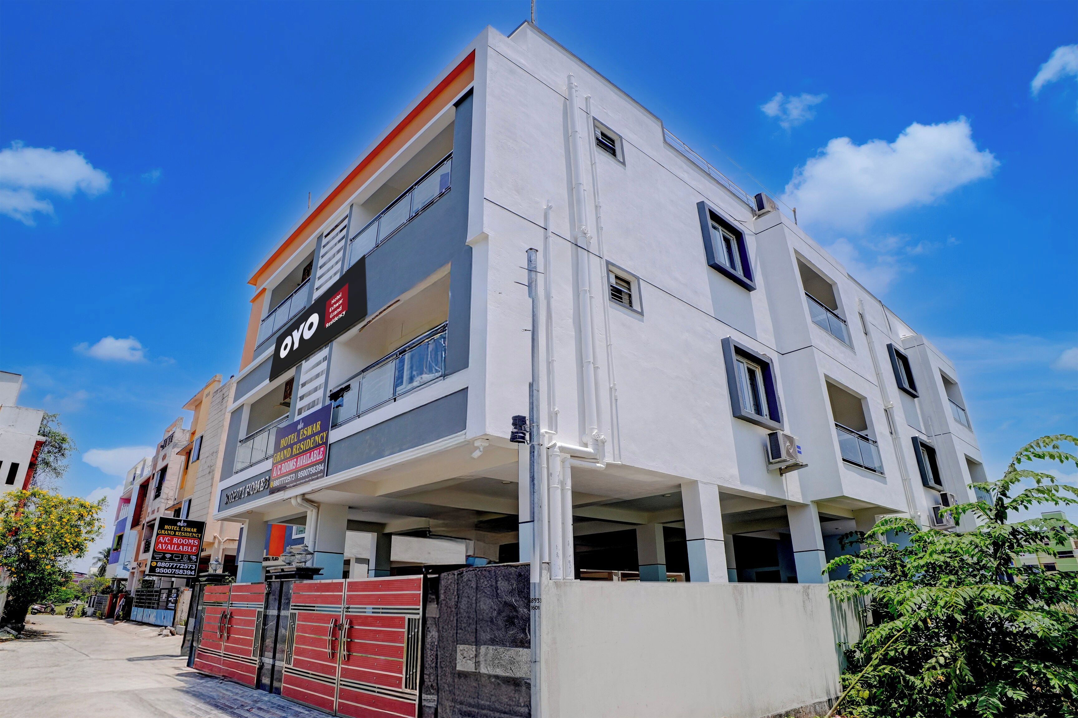 A multi-story building with balconies, a sign for hotel residency, and a gated entrance.
