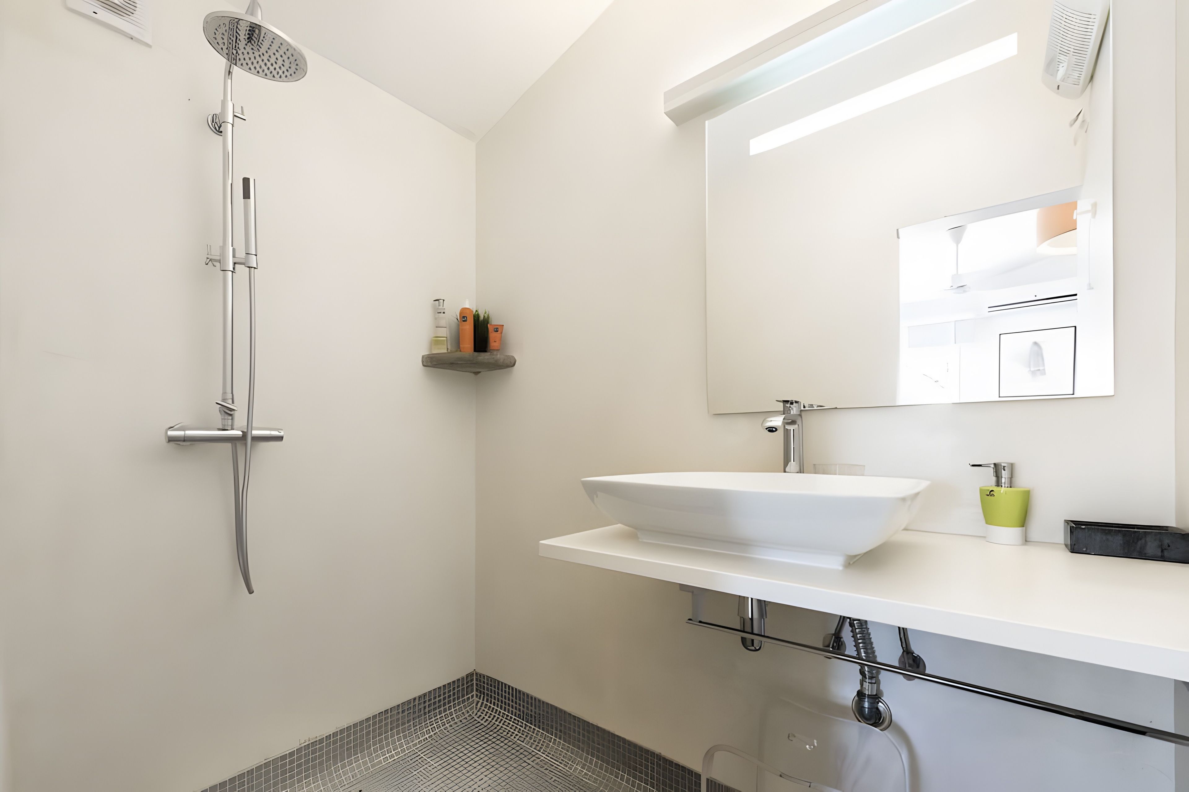 A modern bathroom with a shower, a sink, and a mirror.