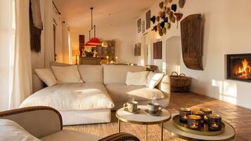 A cozy living room with a sectional sofa, a fireplace, and a dining area with candles.
