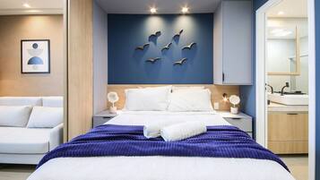 Un dormitorio moderno con una cama, mesitas de noche y una lámpara fijada a la pared.
