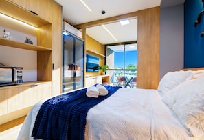 A modern bedroom with a bed, a desk, and a view of the outdoors. - Beach Class Verano Resort Resort With Full Facilities Just a Few Meters From Muro Alto Beach (Ipojuca)