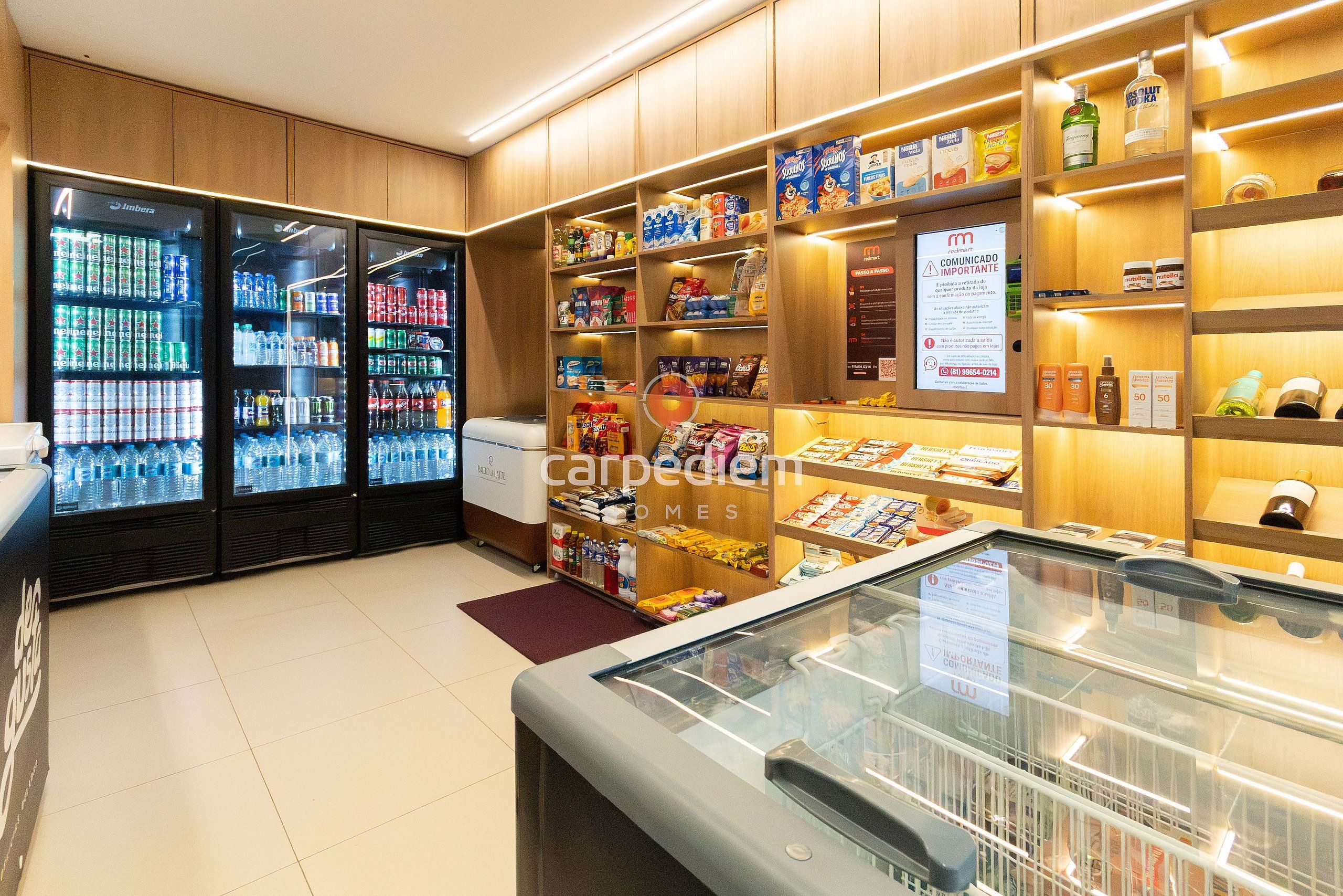 Una tienda minorista con dispensadores de bebidas refrigeradas, pasillos de aperitivos y una gran variedad de productos envasados.