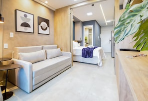 A hotel room with a sofa, a bed, a bathroom with a shower, and a reception desk. - Beach Class Verano Resort Resort With Full Facilities Just a Few Meters From Muro Alto Beach (Ipojuca)