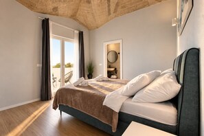 A bedroom with a bed, a bathroom with a sink, and a balcony with a chair. - Holiday House Mountain View Retreat (Kršan)