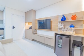 Eine moderne Küche mit integriertem Fernseher, Kühlschrank und Dekoration auf den Regalen.