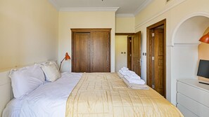 Ein Hotelzimmer mit einem Bett, einem Schreibtisch, einem Fernseher und einem Kleiderschrank.