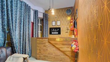 A reception area with a wooden reception desk, a clock, and a fire extinguisher.