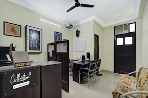 A reception area with a reception desk, a computer, and a wall-mounted air conditioning unit. - Collection O Patliputra Station (Danapur)