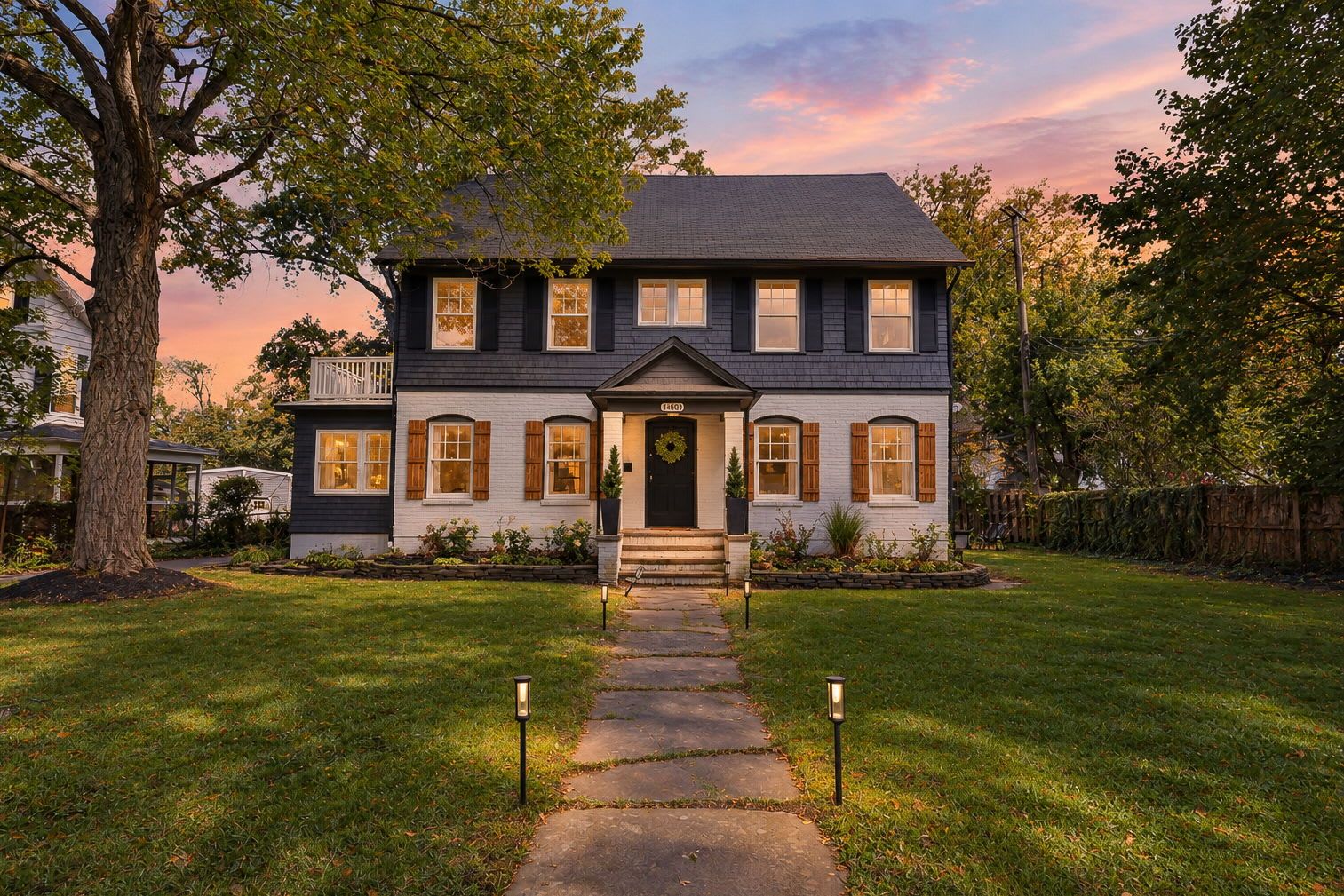A two-story house with a front porch, a visible number '140', and a well-maintained lawn.