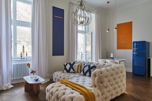 Ein modernes Wohnzimmer mit einer Couch, einem Sessel und einem Esstisch.