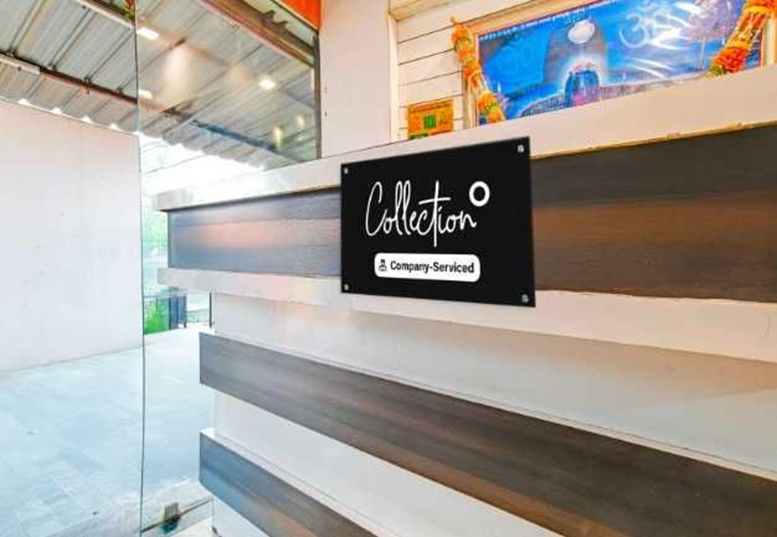 A sign with the word 'Collection' and 'Company-Serviced' on a wall.