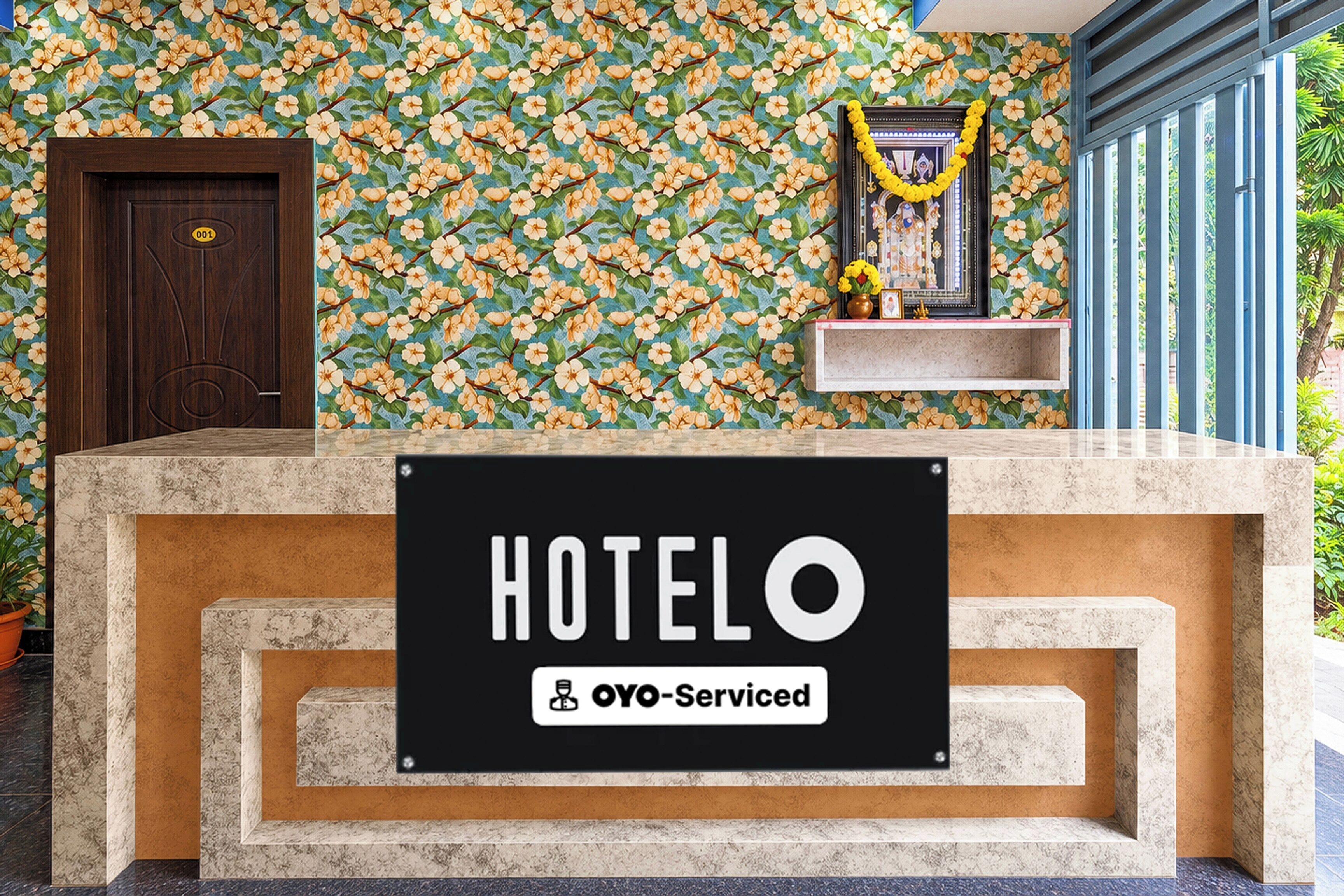 A hotel reception desk with a sign reading 'HOTELO' and 'OYO-Serviced'.