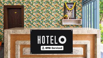 A hotel reception desk with a sign reading 'HOTELO' and 'OYO-Serviced'.