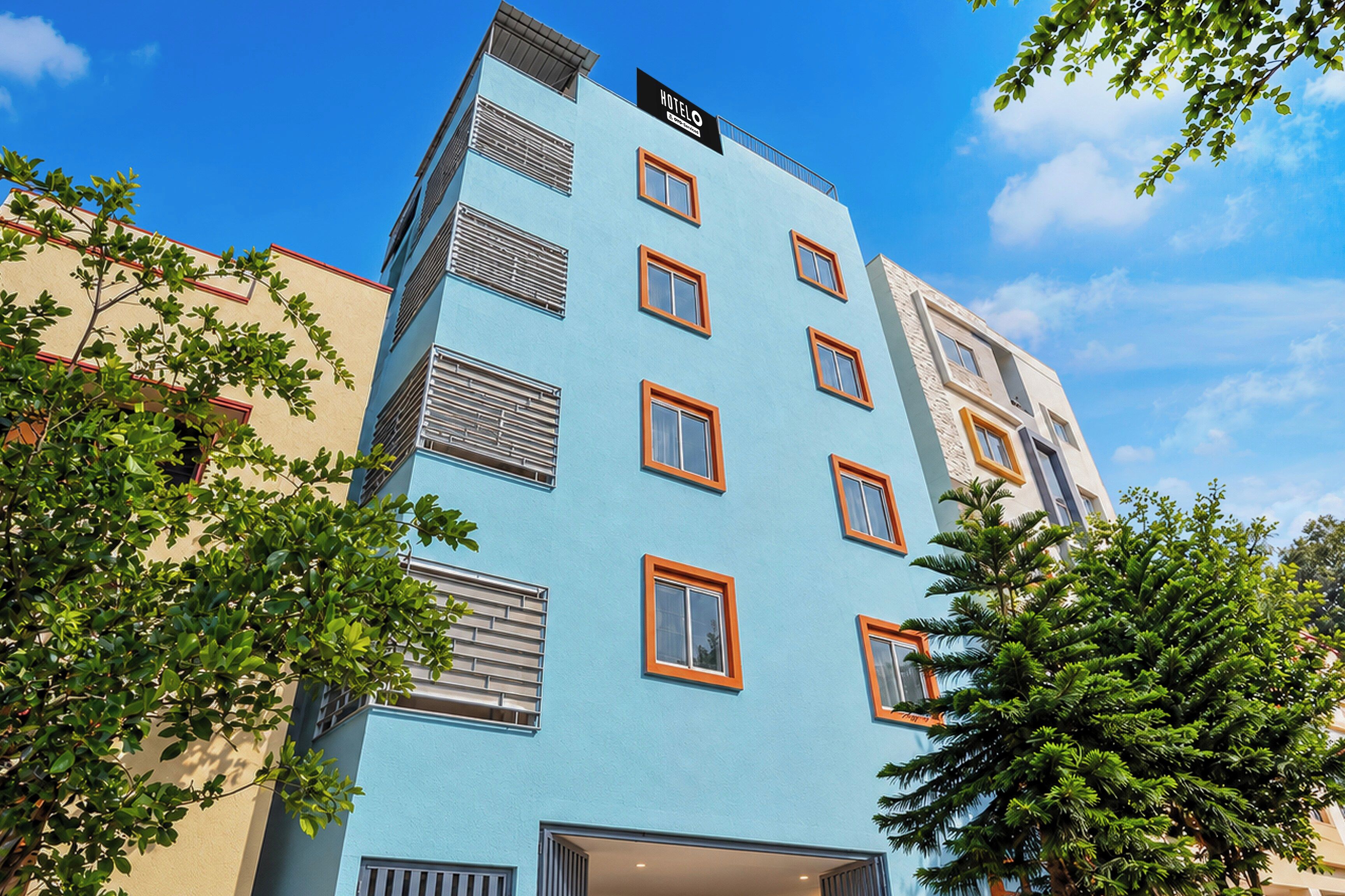 Un edificio de hotel de varios pisos con fachada azul, múltiples ventanas y un letrero que indica que es un hotel.