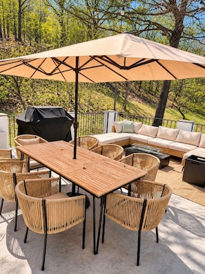 An outdoor patio with a wooden table and chairs, a large umbrella, a barbecue grill, and a sofa. - Mountain views, Family friendly, 4 Bed and 3 Bath Home Near Windham Mountain (Acra)