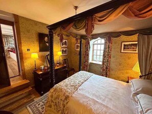 Ein traditionell eingerichtetes Schlafzimmer mit Himmelbett, Schminktisch und Schreibtisch.