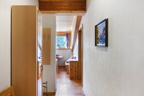 A narrow hallway with wooden floors and walls, leading to a room with a bed and a window. - Apartment 'Frelich  1' with Mountain View, Shared Pool and Wi-Fi (Lagundo)