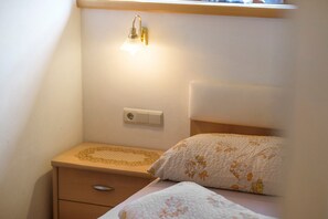A bedroom with a bed, a bedside table, a wall-mounted light, and a power outlet. - Apartment 'Frelich  1' with Mountain View, Shared Pool and Wi-Fi (Lagundo)