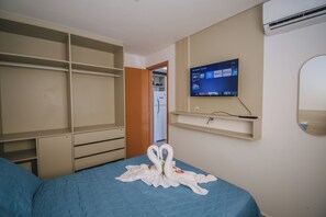 Ein Hotelzimmer mit einem Bett, einem Kleiderschrank, einem Fernseher und einem Spiegel.