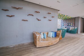 Ein Zimmer mit einer Holzbänkl, Kissen und einer Wand mit dekorativen Holzelementen.
