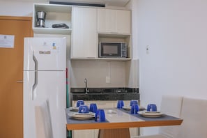 A compact kitchenette with a refrigerator, microwave, and a coffee maker on the upper shelf. - MG01J  Bella V.  Ap. 105 B  Andres Sardi (Ipojuca)
