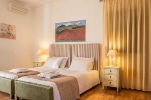 A hotel room with a bed, two bedside tables, a lamp, a painting, and a curtain. - Peaceful Pool Villa in Crete Countryside (Crete)