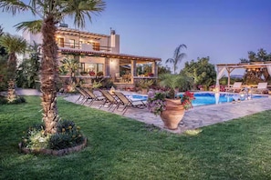 A residential property with a swimming pool, outdoor seating, and a well-maintained garden. - Peaceful Pool Villa in Crete Countryside (Crete)