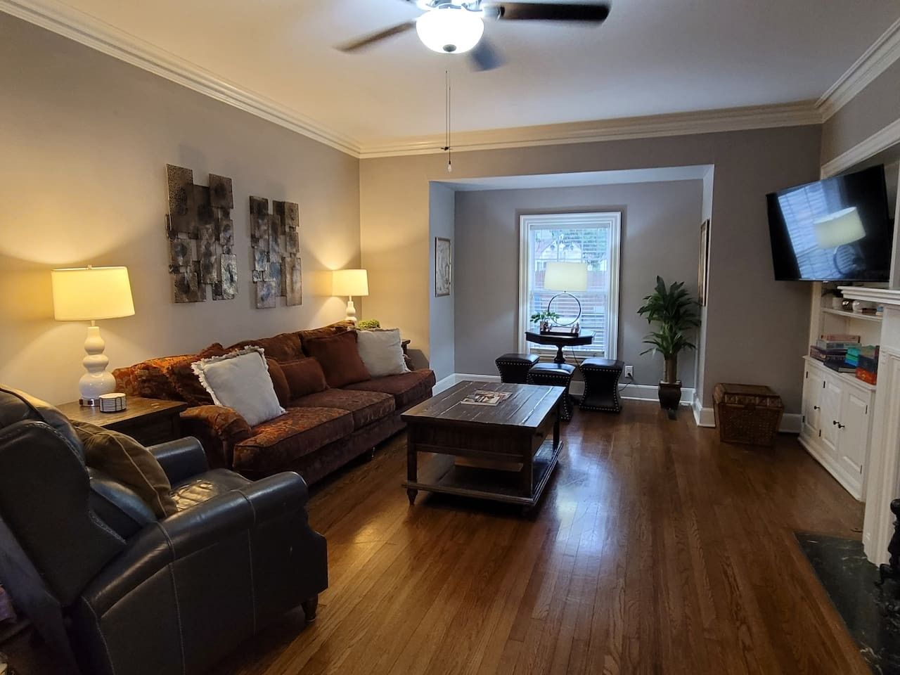 Ein Wohnzimmer mit einer Couch, einem Couchtisch und einem Fernseher.