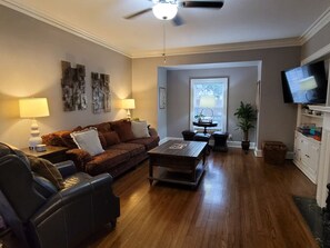 Ein Wohnzimmer mit einer Couch, einem Couchtisch und einem Fernseher.