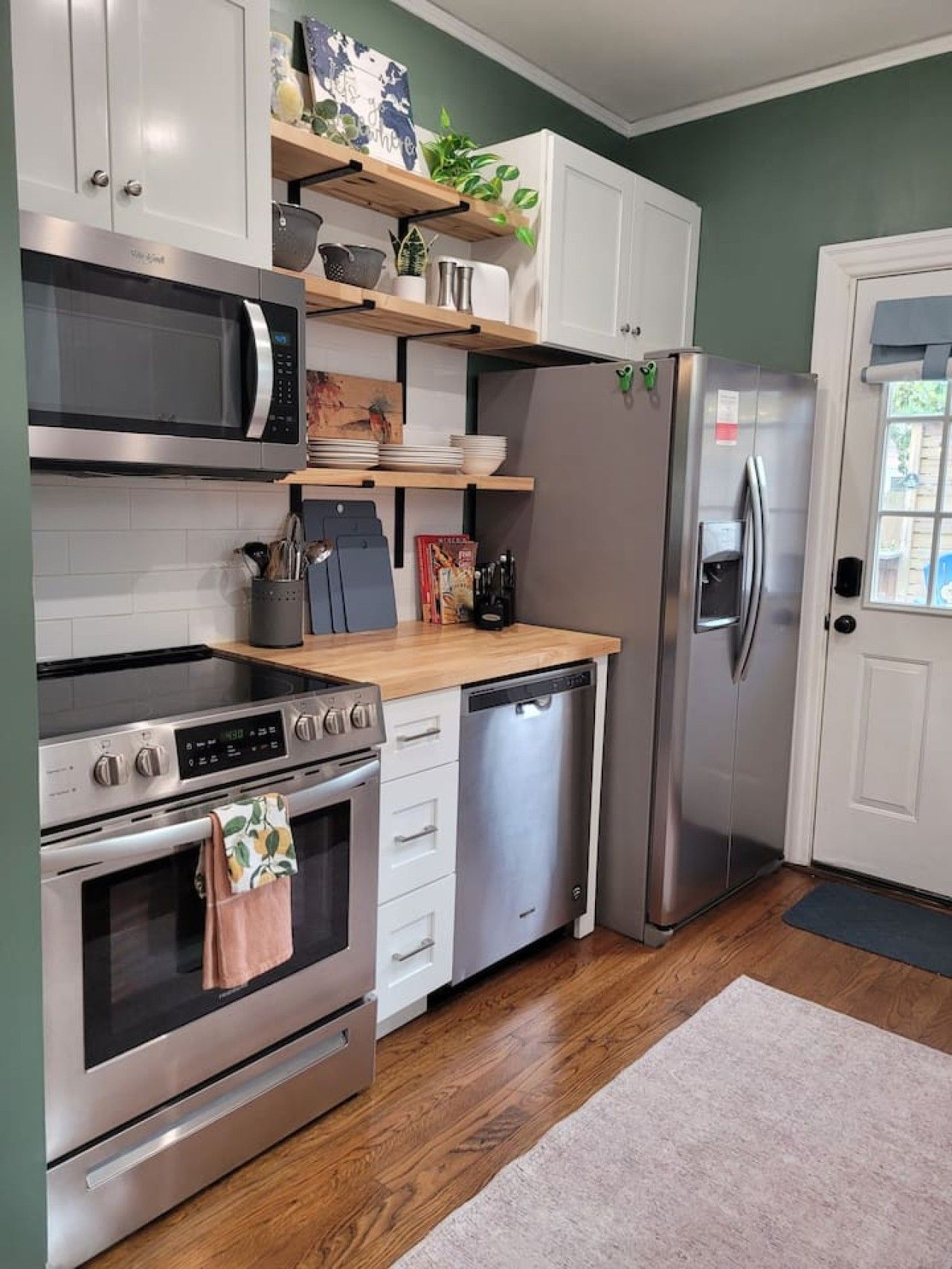 Eine moderne Küche mit Edelstahlgeräten, Holz Arbeitsplatten und einem eingebauten Backofen.