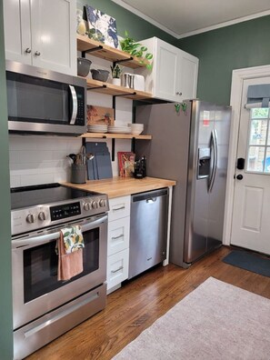 Eine moderne Küche mit Edelstahlgeräten, Holz Arbeitsplatten und einem eingebauten Backofen.