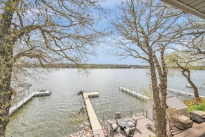 Eine Seeterrasse mit Sitzgelegenheiten im Freien und einem Steg, der ins Wasser führt.