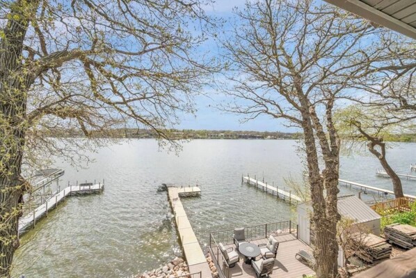 Una terrazza sul lago con posti a sedere all'aperto e un molo che si protende nell'acqua.