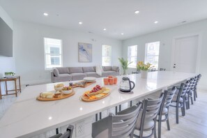 A spacious kitchen with a long island, modern appliances, and a seating area with a sofa. - Ocean Views • Private Pool and Spa • 12 Sleeping Rooms • Sleeps 28 (North Myrtle Beach)