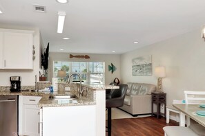 A modern kitchen with granite countertops, a built-in sink, and a coffee maker. - 🌴Snapper Landing | Steps to Beach | Pool | Pet Friendly🌴 (Mexico Beach)