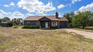 A single-story house with a front porch, a garage, and a fenced yard.
