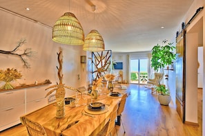 A dining area with a wooden table, wicker chairs, and hanging wicker lamps. - Le Balcon des Sanguinaires - Vue sur la mer (Ajaccio)