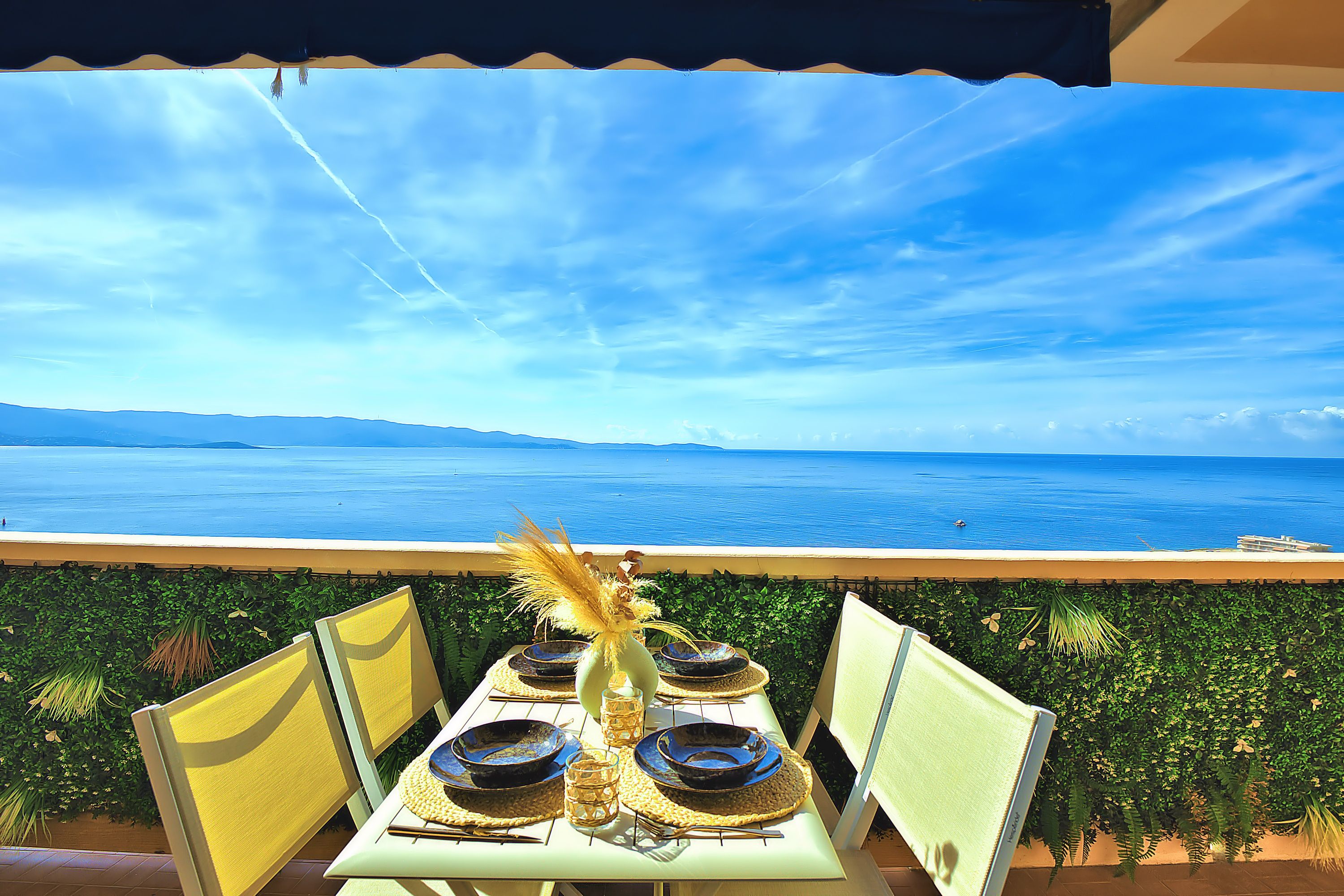 A table set for dining with a view of the sea.